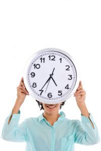 hipanic woman holding big clock on her face