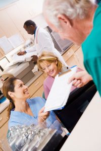 Nurses Being Handed A Clipboard At The Reception Area In A Hospi