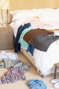 Clothes Scattered On Floor And Hotel Bed