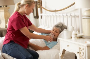 Health Visitor Giving Senior Woman Glass Of Water In Bed At Home