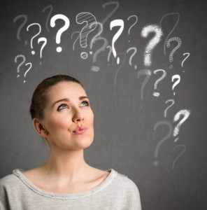 Young woman thinking with question marks over head