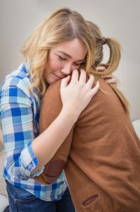 Mother embracing and soothes depressed daughter