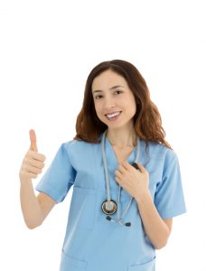 Friendly female medical worker showing thumbs up
