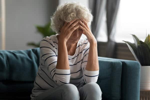Older woman sitting in a care home in the lounge alone